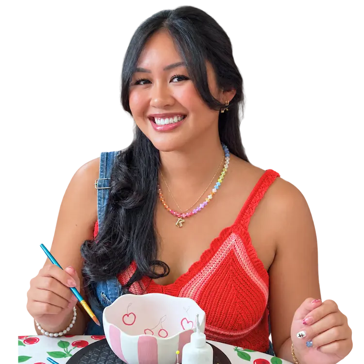 Guest painting colorful pink and red pottery at The Hot Spot Studios